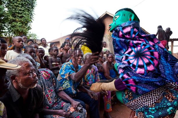 Tam village Benin- mars 31-2021: Gelede a form of 'Espirit performs a dance ahead of a Voodoo ceremony. They take care of the community and ask for the rains for crops.\n\nThe Gẹlẹdẹ spectacle of the Yoruba is a public display by colorful masks which combines art and ritual dance to amuse, educate and inspire worship. Gelede celebrates “Mothers” (awon iya wa), a group that includes female ancestors and deities as well as the elderly women of the community, and the power and spiritual capacity these women have in society. Focusing not only on fertility and motherhood but also on correct social behavior within the Yoruba society.