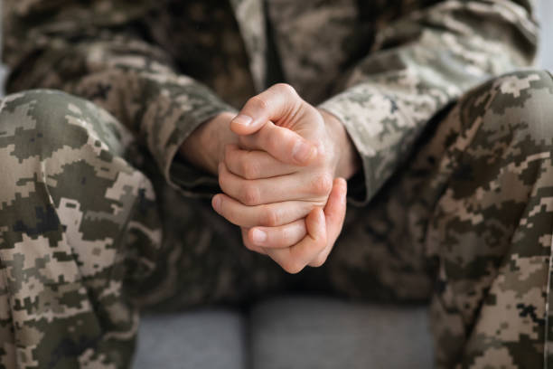 cropped of soldier sitting on couch alone - mental health depression illness healthy lifestyle imagens e fotografias de stock