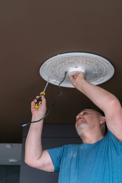 istock A man installs a chandelier on the ceiling 1467633074