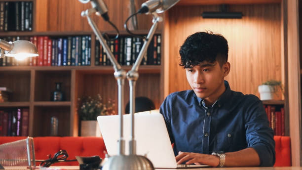 istock Young asian is working on laptop in the library 1467637357