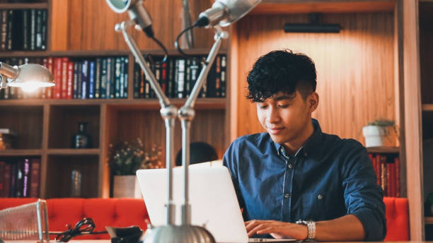 istock Young asian is working on laptop in the library 1467637369
