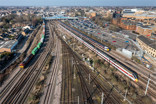Peterborough, UK - February 13, 2023.  Aerial cityscape view of LNER passenger and freight trains arriving and departing from Peterborough Railway Station on the ECML