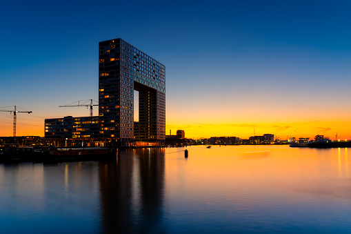 Amsterdam, Netherlands. A cityscape in the evening. A skyscraper and business center near the water in the bay. Architecture of the Netherlands. Travel photography.