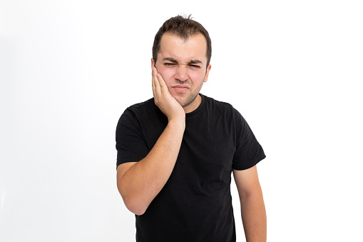 Frustrated young man suffering from toothache. Young men isolated on white background.