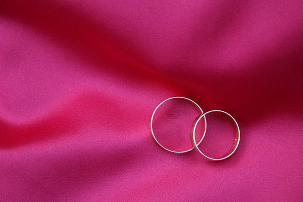 istock Romantic Wedding Rings on Pink Satin 146764292