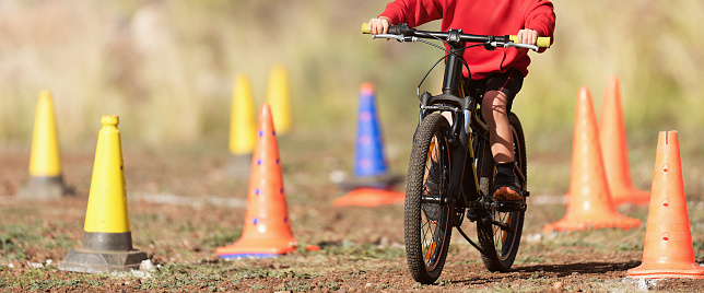 Child riding his bike during a race going around cones along the route