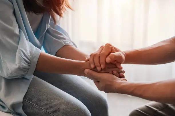 Young man comforting and supporting a sad woman who is in serious trouble at home, Consolation and encouragement concept