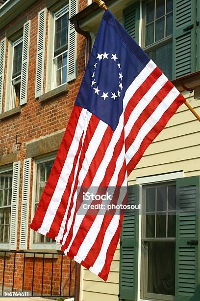 American Colonial Flag Hanging In Front Of Period Homes Stock Photo - Download Image Now