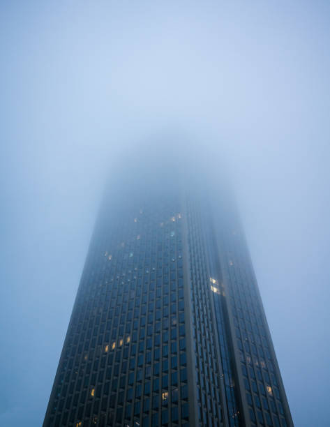 looking up at skyscrapers at a foggy overcast day stock photo