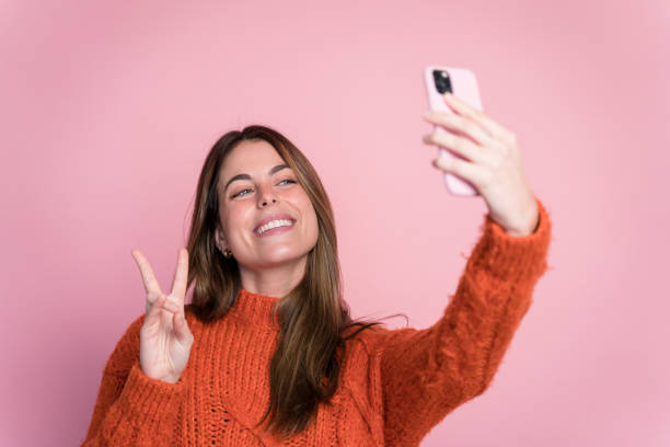 istock Smiling woman in sweater taking selfie 1467650263