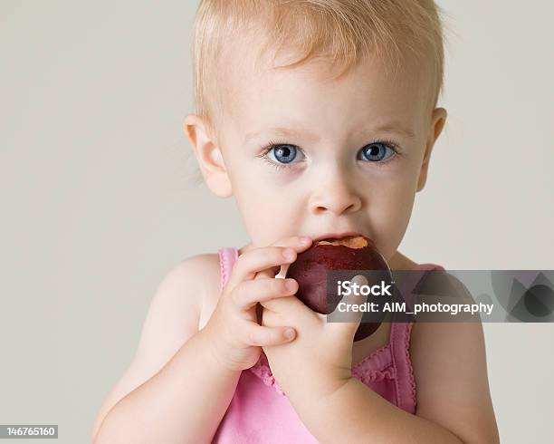 Bonito Bebê Menina Comer Um Ameixa - Fotografias de stock e mais imagens de Ameixa - Fruta - Ameixa - Fruta, Comer, Criança