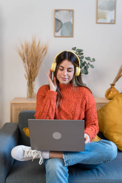 istock Happy woman using laptop on sofa 1467652413