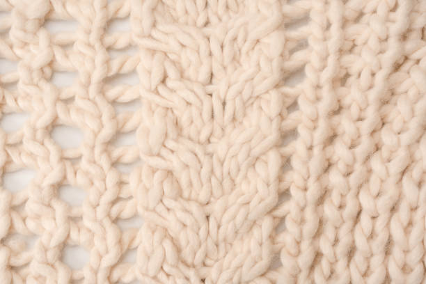 istock A fragment of beige knitted fabric, knitted from white sheep wool. 1467652504