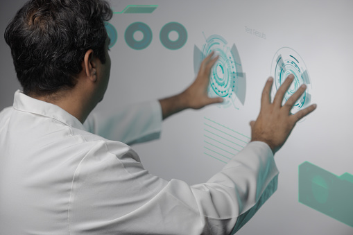 Scientist using a holographic screen created with royalty-free stock vectors and modified accordingly.
