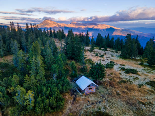 Tiny wooden shelter lost in the mountains. Going into the wild