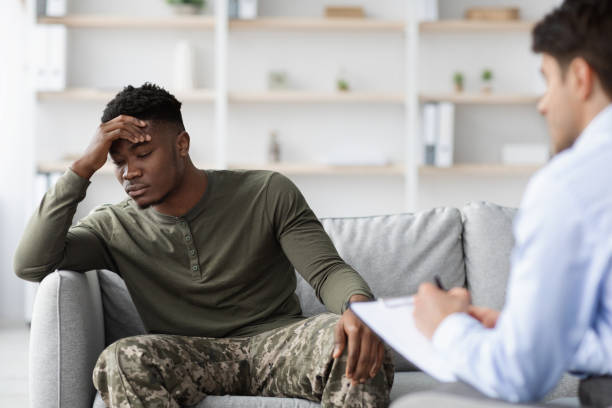 istock Frustrated man in camouflage having conversation with psychologist, copy space 1467665206