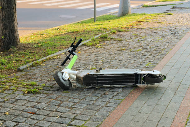 Electric scooter lies on the sidewalk in the city stock photo