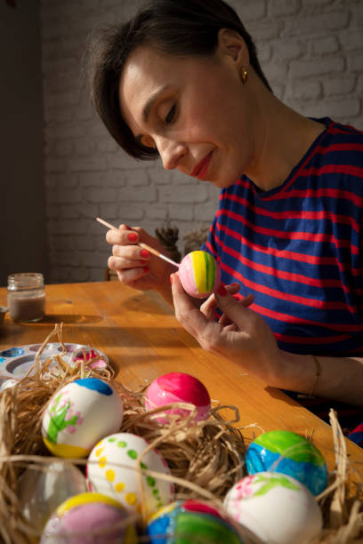 istock Woman painting Easter Egg and preparing for Easter holiday celebration 1467665729