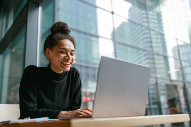 istock Smiling female freelancer working on laptop while sitting in cafe near window. Distance work 1467668018