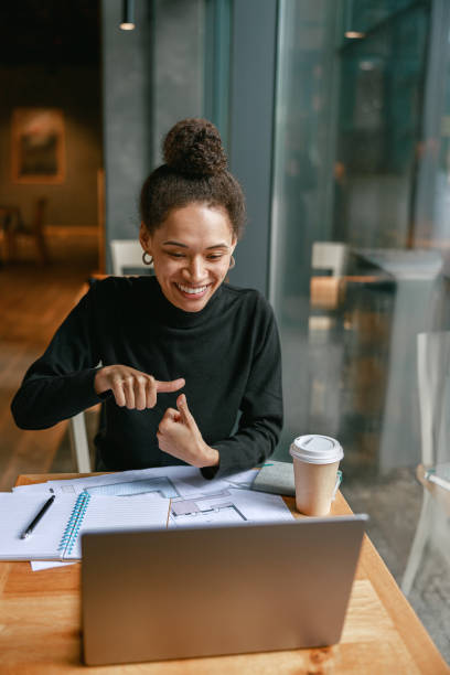 istock Woman freelance architect talking with client via video call and discuss project sitting in cafe 1467668254