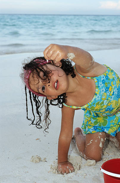 istock little girl on the beach playing with sand 146767230