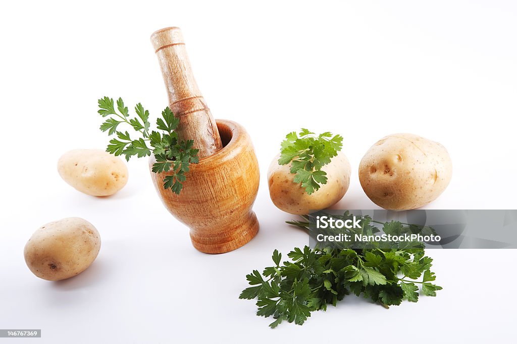 Kitchen scene Kitchen scene consisting in mortar and pestle potatoes and parsley Food Stock Photo