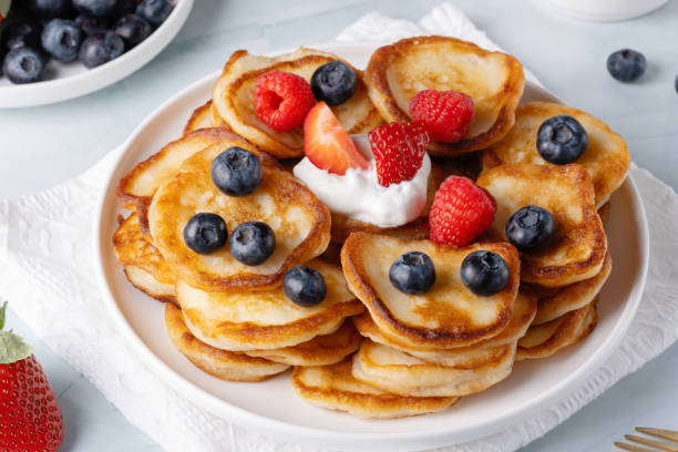 Homemade mini pancakes with blueberries, strawberries and raspberries