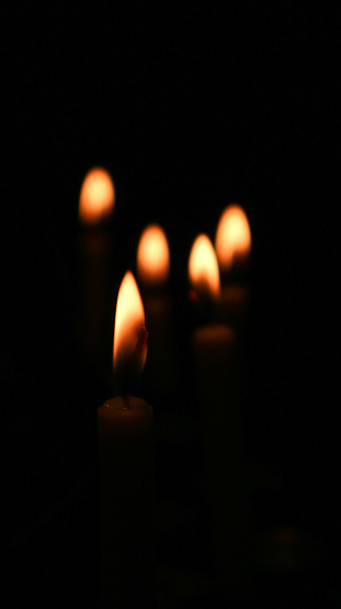 Close up of burning candles in a dark room