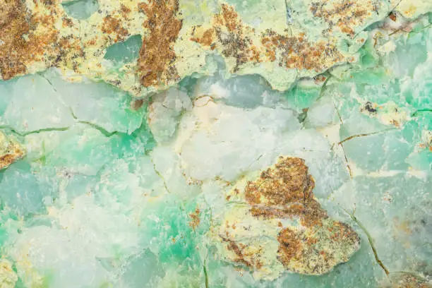 Waxy surface of Chrysoprase mineral with visible traces of nickel in apple green parts of the texture.