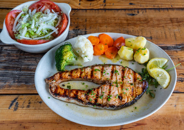 filete de salmão grelhado em um prato com salada de legumes e batatas cozidas. comida tradicional portuguesa cheia de ómega 3. - ómega 3 - fotografias e filmes do acervo