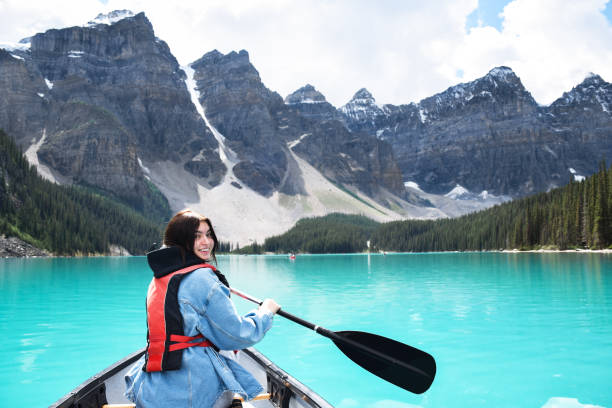 istock Young girl looking back over shoulder smiling while riding in canoe 1467679223