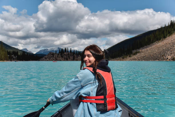 istock Young girl looking back smiling while paddling in a canoe 1467680909
