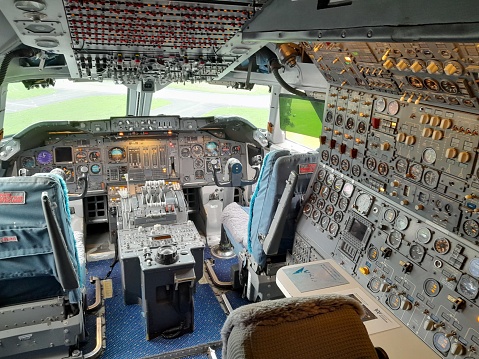 cockpit view of a commercial jet airliner with pilot in cruise phase of flight.