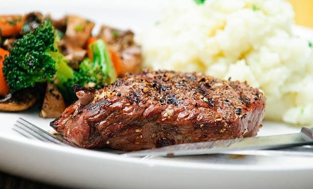 A steak dinner with mashed potatoes and vegetable medley stock photo