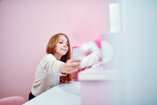 Female Child Arranging Her Room At Home