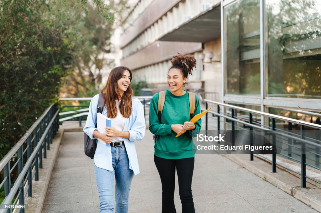 University student girl friends with learning books walking out School building University Stock Photo
