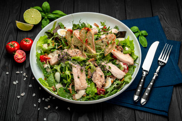 istock Fresh caesar salad in white plate on dark wooden table. 1467687342