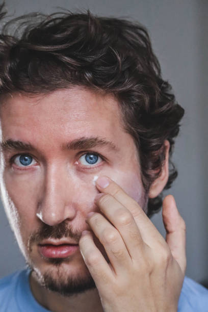 istock Handsome young man applying cream on his face 1467688966