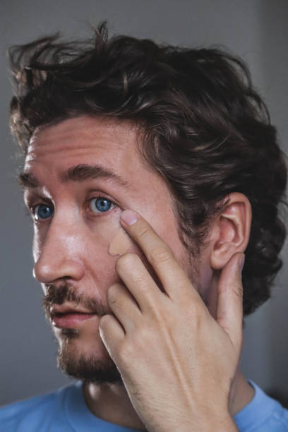 istock Handsome young man applying foundation to his face 1467689142