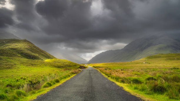 droga prowadząca przez dolinę doolough, pomiędzy pasmami górskimi, irlandia - republic of ireland mayo road lake zdjęcia i obrazy z banku zdjęć