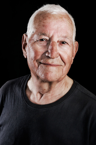Portrait of an old smiling man with white hair and black t-shirt.