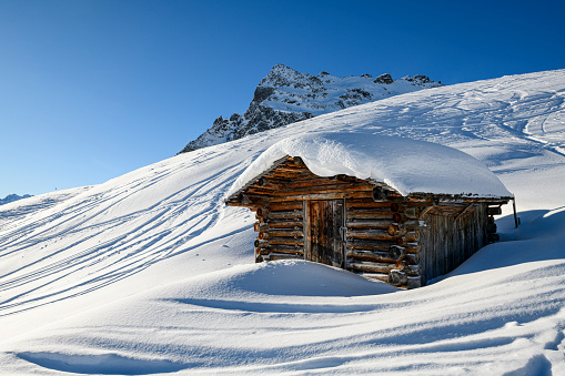 Snowcapped old hut in the mountains in the ski-resort Gargellen