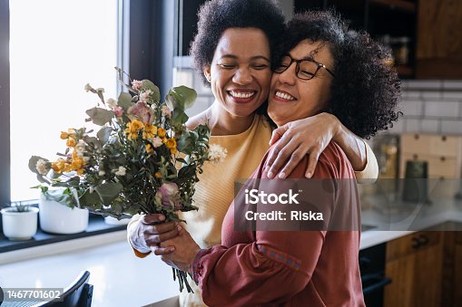 istock Mature woman giving flowers to her wife 1467701602