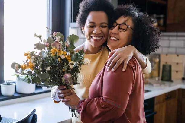 Photo of Mature woman giving flowers to her wife