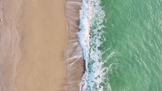 Aerial drone flight over the sea line breaks waves on the sandy beaches in Areyns de Mar