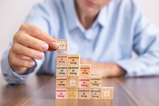 Business woman holding crown wooden block, content concept on wooden blocks.