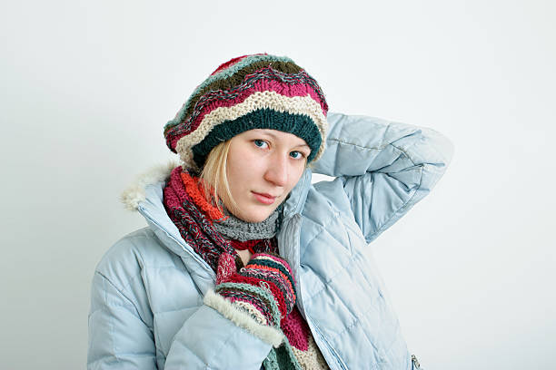 Portrait of the woman in a winter cap, mittens and a scarf.