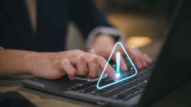 istock Businesswomen using computer laptop or tablet with triangle caution warning sign for notification error and maintenance concept. 1467709469