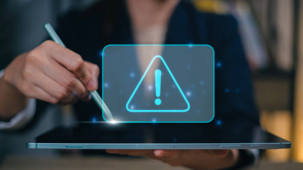 istock Businesswomen using computer laptop or tablet with triangle caution warning sign for notification error and maintenance concept. 1467709485