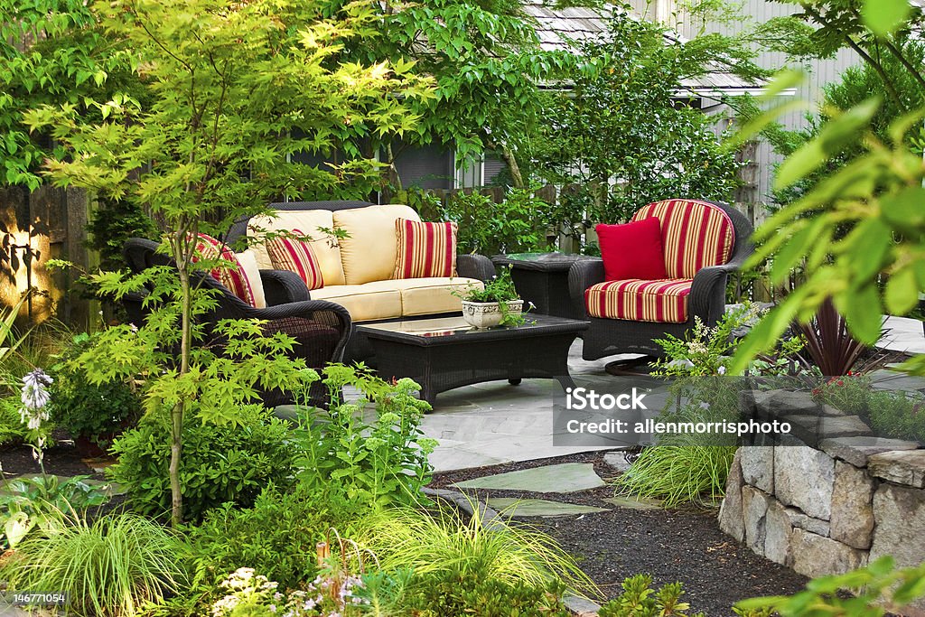 Outdoor Living Room Outdoor living space including wicker furnishings, stone masonry, and plant landscaping. Home located in Oregon. Living Room Stock Photo